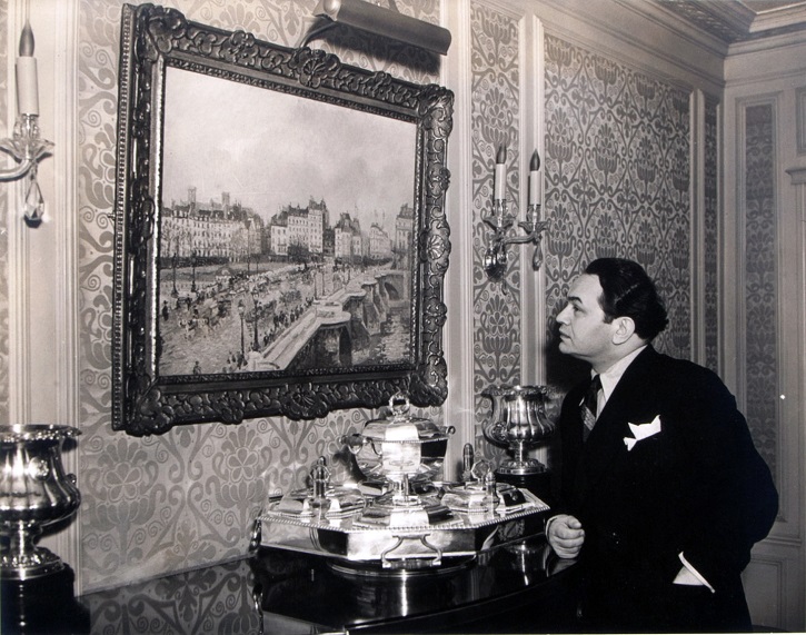 En su casa frente a un Pissarro, Le Pont Neuf. Robinson ostentó la mayor colección de arte impresionista de los EE. UU. y fue el primero en comprarle cuadros a Frida Kahlo. Todo un mecenas de las artes. Perteneciente a un álbum de fotos propiedad de la familia Robinson que salió a subasta a través de la casa Juliens Auctions | ‘Todos mis ayeres’: Ananda Segarra revive en español a Edward Robinson